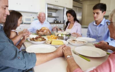 Family prays over a thanksgiving meal.