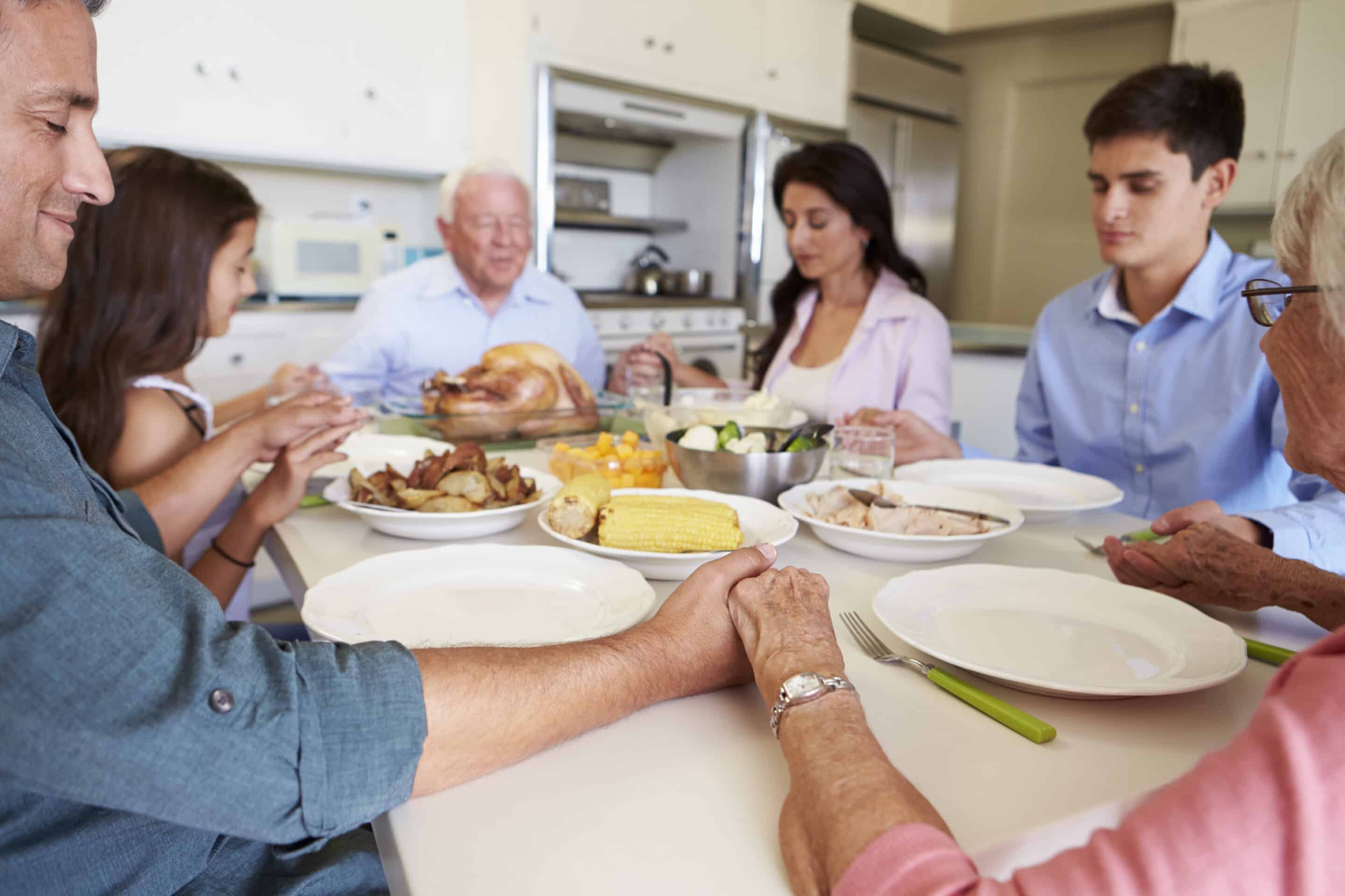 Family prays over a thanksgiving meal.