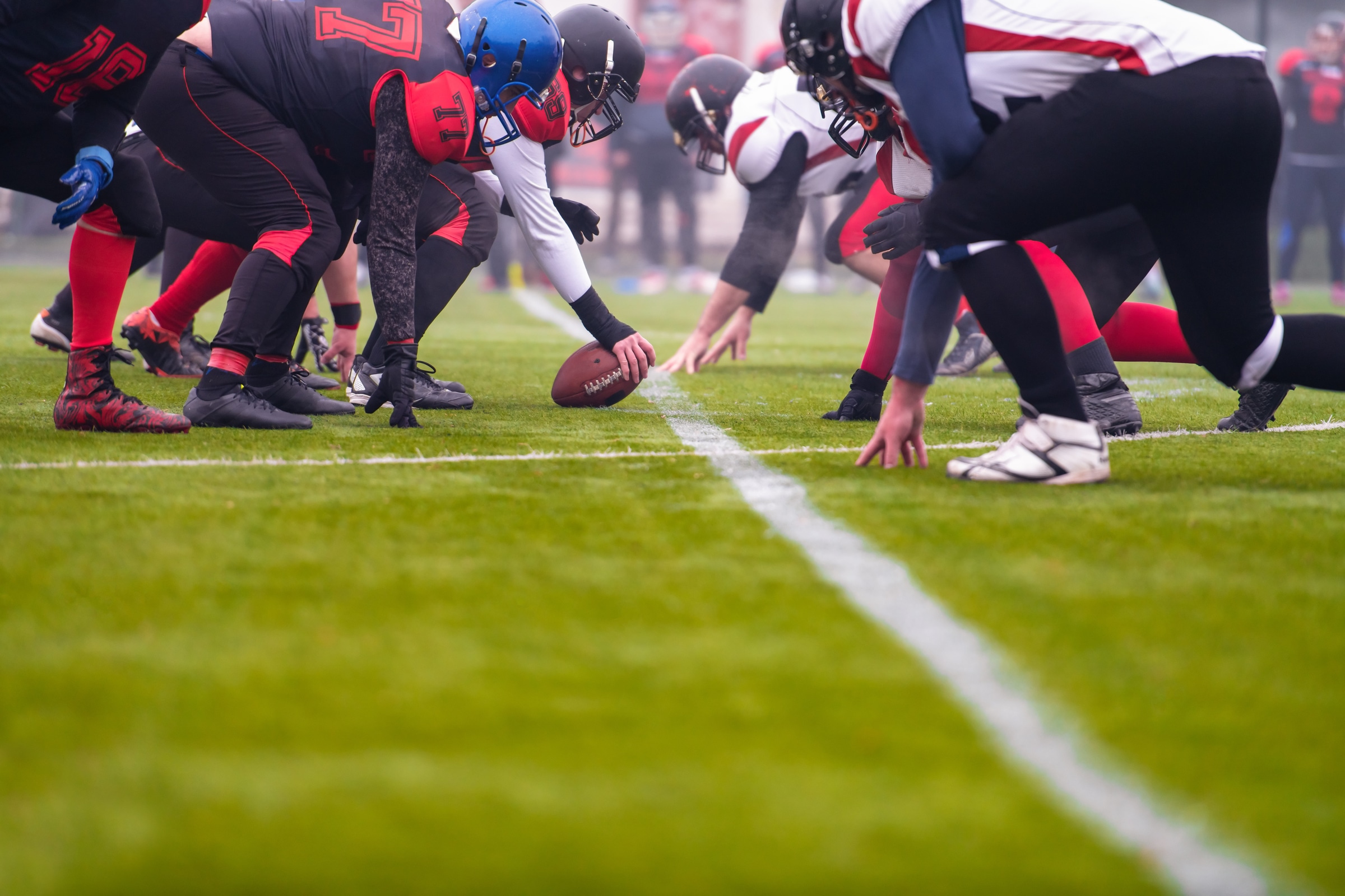 group of young professional american football players ready to start during match on the stadium field