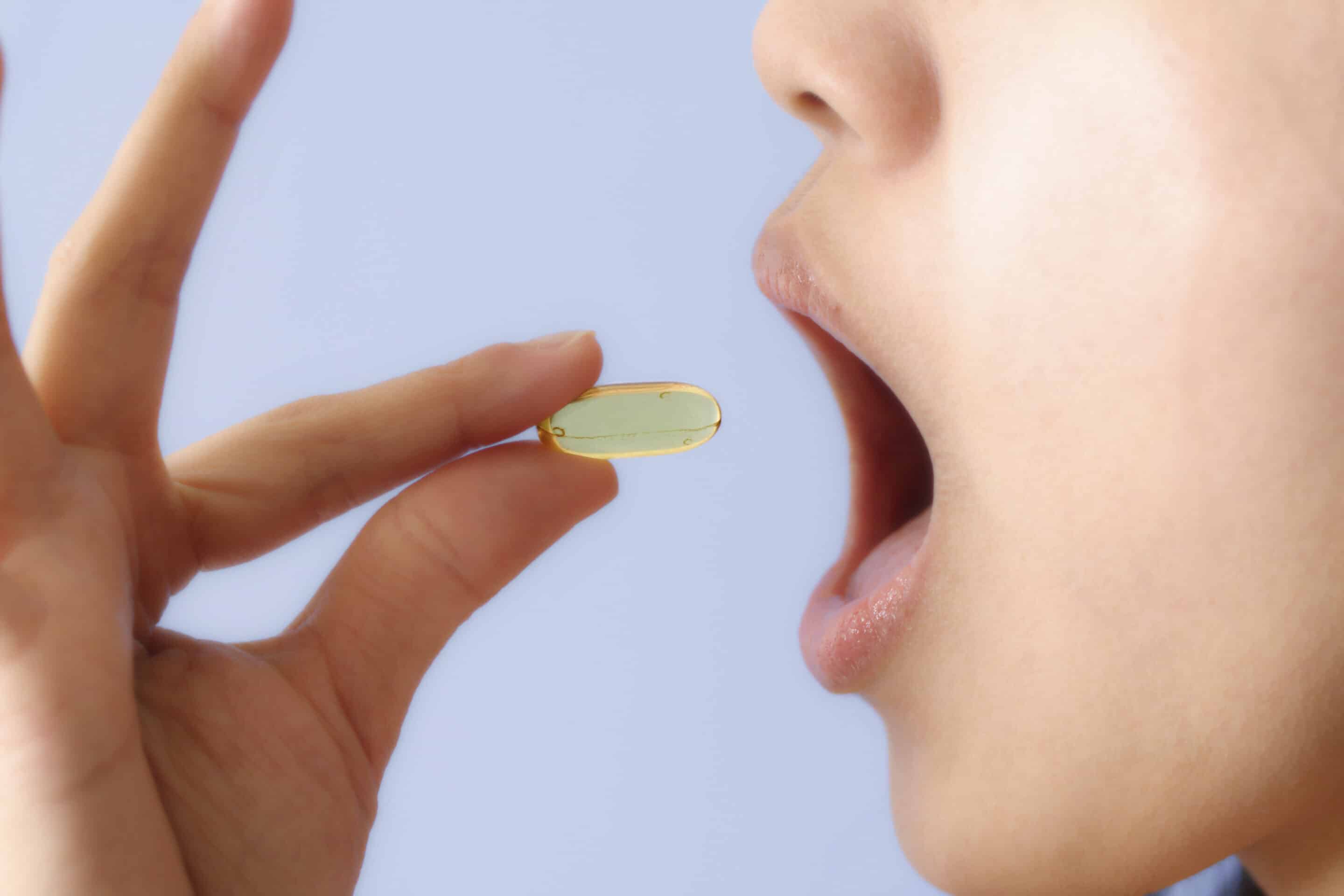 A woman taking a pill/vitamin